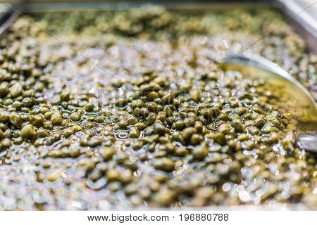 Macro Closeup Of Small Green Capers In Olive Bar