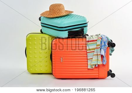 Bags for clothes for vacation. Suitcases, strawy hat, clothes. Preparation for summer recreation.