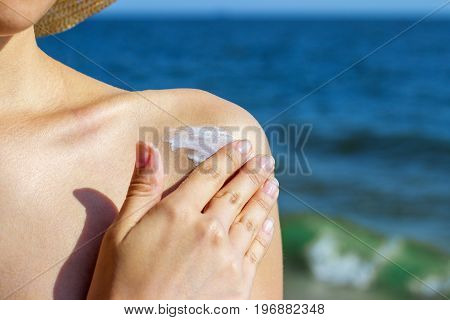 Girl applying sun lotion on the beach