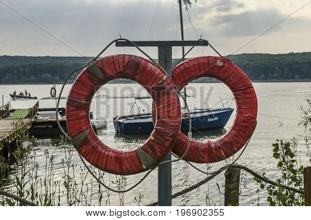 Two red life buoys against the backdrop of a yacht