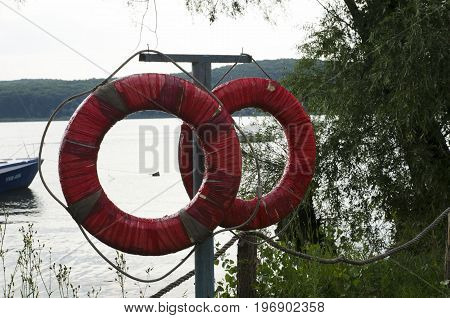 Two red life buoys against the background of a river