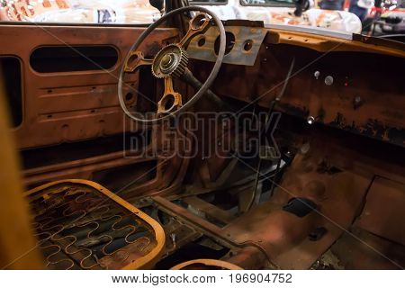 Rusty interior of an old car. Close up of Car steering wheel and dashboard panel with rust and dust.