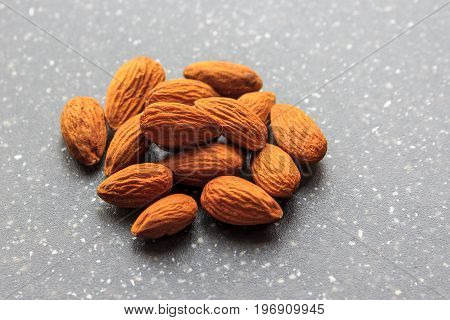 healthy dried almonds in pile on granite background