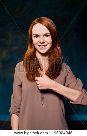 beautiful young red-haired teen showing thumb up and smiling