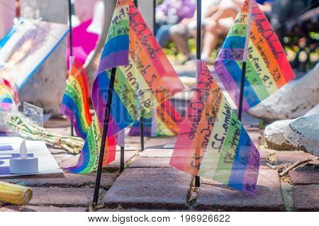 ORLANDO, USA - MAY 05, 2017: Small gay flags in the ground, place where Omar Mateen, killed 49 people and wounded 53 others in a terrorist attack hate crime in a gay nightclub in Orlando, Florida, United States.