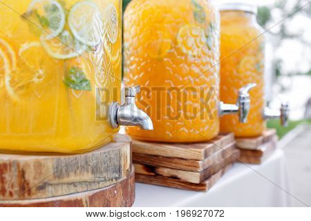 Jar of tasty fresh lemonade with ice and mint. appetizers, canapes and bruschetta on background. the fourchette in the open air. professional catering. Wedding decor