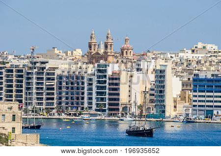 Sliema Malta - June 4 2017: Sliema Waterfront densely covered with modern buildings Sacro Cuor Parish Church and sailing boats as seen from Valletta.