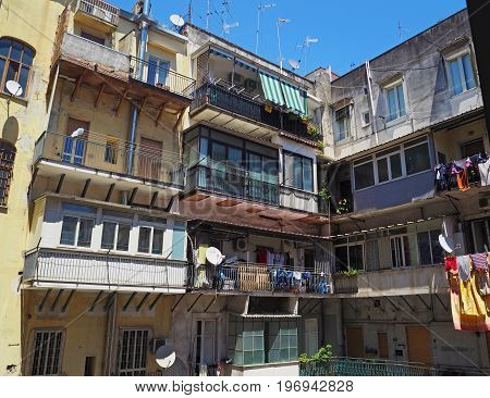 colourful inner yard in old Neapol apartment house with balcony flowers clothes and antens