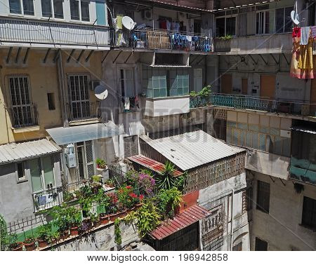 colorful inner yard in old Naples apartment house with balcony flowers clothes