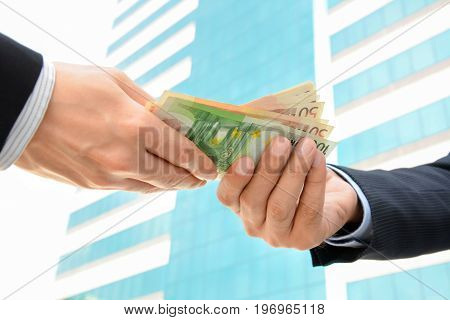 Two Businessmen Echanging Money To Each Other
