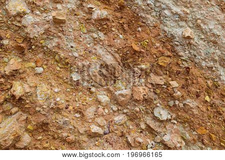 Red and white loam surface with parts of camstone. Textured background.