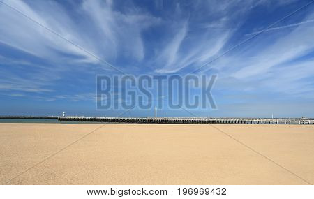 Beach on a sunny summer day. White sand under blue vibran sky.