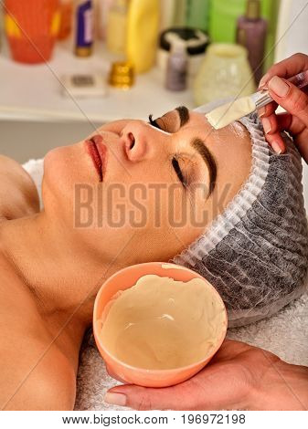 Collagen facial mask for skin treatment. Face of woman with close eyes of elderly woman 50-60 years old receiving cosmetic procedure in beauty salon close up. Professional beautician.