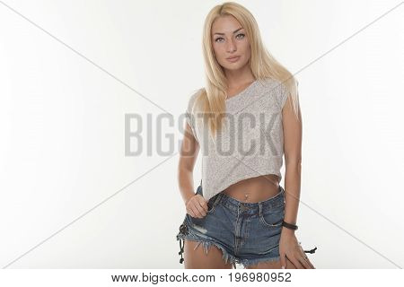 Young sexy blond woman in jeans shorts isolated on white