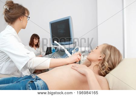 Professional gynecologist performing breast examination for her patient using ultrasound scanner medicine healthcare cancer awareness checkup clinic profession procedure.