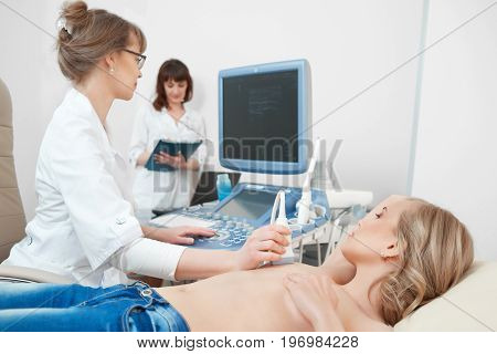 Shot of a young woman visiting her gynecologist getting breast examination with ultrasound scanner technology modern medicine cancer awareness sonogram.