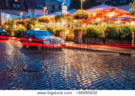Riga, Latvia - July 3, 2016: Taxi Car Mercedes-Benz W140 Wait Clients Near Open Air Leisure Venue Recreation Center Egle In Evening Or Night Illumination In Old Town On Kalku Street
