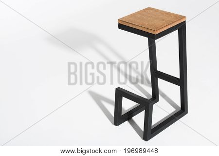Studio Shot Of Stylish Barstool With Wooden Top And Black Metallic Legs Standing On White