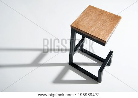 Studio Shot Of Stylish Barstool With Wooden Top And Black Metallic Legs Standing On White