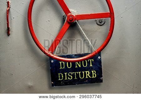 Do Not Disturb Warning Sign Plate Hanging On A Hermetic Bomb Shelter Armored Door