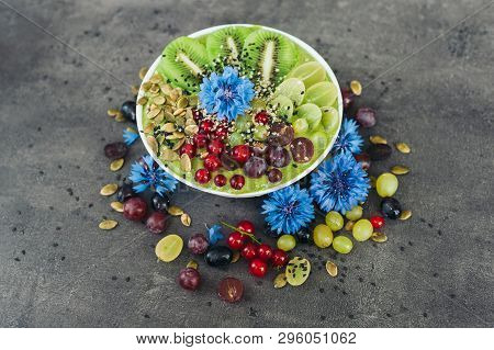 Bowl With Fresh Kiwi Salad, Seeds, Red Current, Green Grape And Blue Cornflowers Around. Vegeterian 