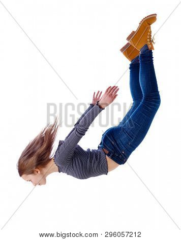 Side view of woman in zero gravity or a fall. girl is flying, falling or floating in the air.  Isolated over white background. The girl in jeans falls down in a free fall.