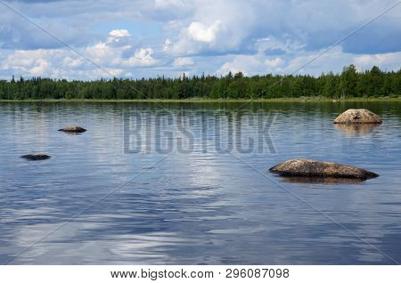 The Beautiful Picture Of Karelian Forest At The Edge Of A Lake, And Some Huge Boulder In This Lake