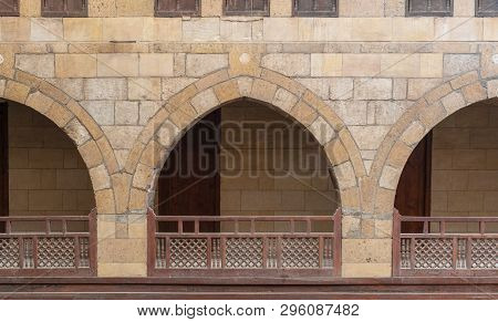 Front View Of Three Arches With Interleaved Wooden Balustrades At The Arcade Surrounding The Courtya
