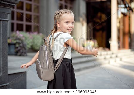Happy Smiling Girl Is Going To School For The First Time With Bag Go To Elementary School. Pupil Go 