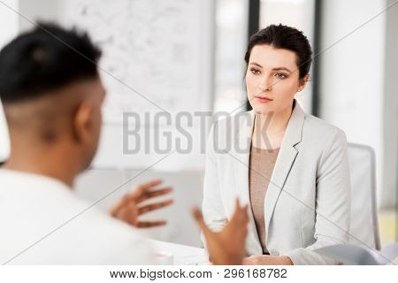 job, business and employment concept - female employer or hr manager having interview with male employee at office