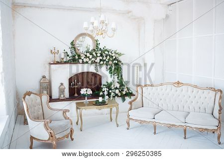 The Fireplace In The Bright Room Is Decorated With Pink And White Roses With Green Branches And Cand