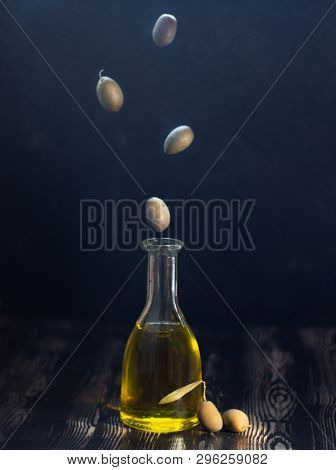 Oil Bottle With Flying Olives With Black Background