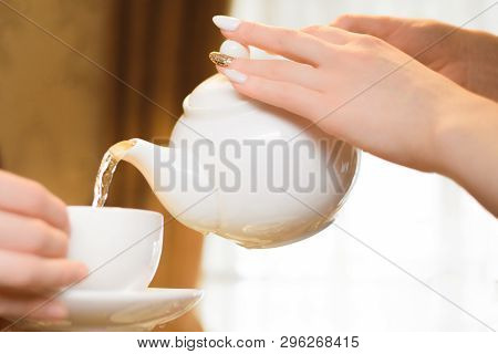 Tea Party. Women Pour Green Tea Into A White Cup