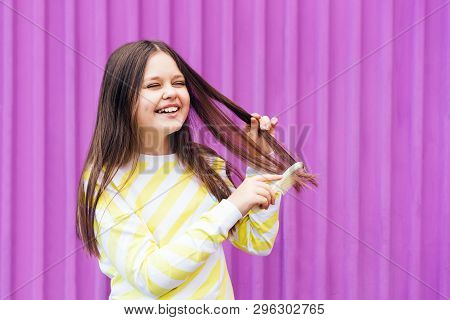 A Long-haired, Cheerful Blonde Girl Ombs Her Hair