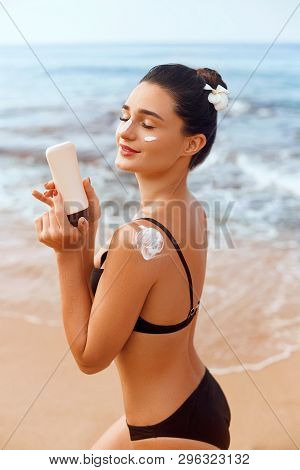 Woman Applying Sunscreen Creme On Tanned Shoulder. Skincare. Body Sun Protection Suncream. Bikini Ha