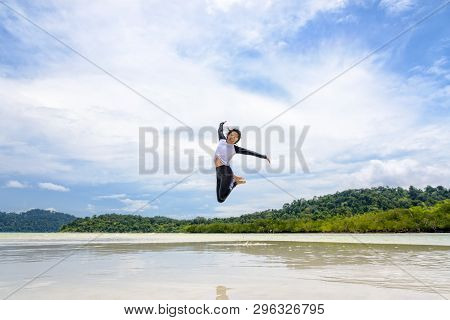 Happy Asian Young Woman Wearing Sunglasses Jumping Fun On The Beach Of Ko Ra Wi On The Blue Sky By T