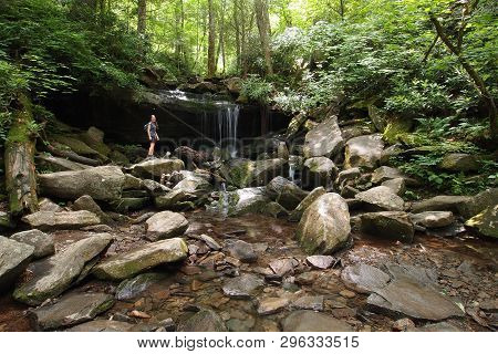 Young Woman Explores A Small Trailside Waterfall In The Great Smoky Mountains National Park, Tenness