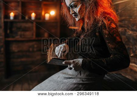 Scary witch reads spellbook, spiritual seance