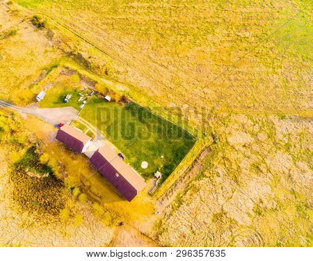 Aerial view to agricultural lanscape with farm house. Sustainable development and ecology.