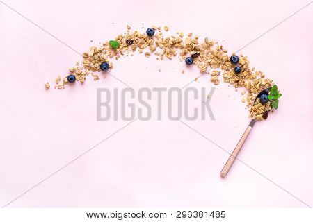 Homemade Granola On Spoon With Bluberries On Pink Background, Copy Space. Healthy Snack Or Breakfast