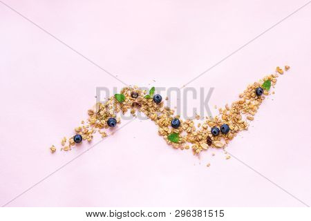 Homemade Granola On Spoon With Bluberries On Pink Background, Copy Space. Healthy Snack Or Breakfast