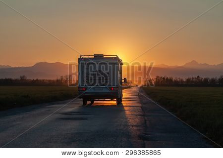 Campervan On The Road Heading To Sunset