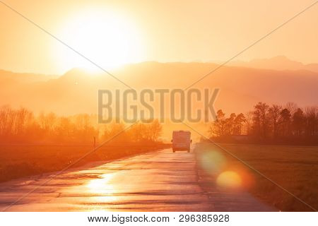 Campervan On The Road Heading To Sunset