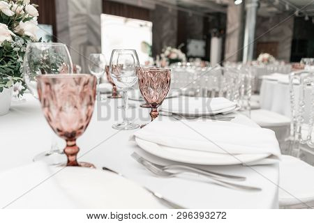 Wine Glasses On Round Banquet Table Served. Interior Of Restaurant For Wedding Dinner, Ready For Gue