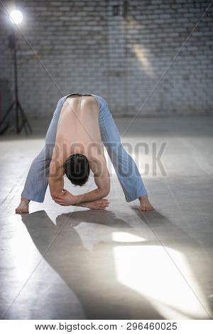 An Athletic Man On Capoeira Training. Bending Down. Spine Stretching