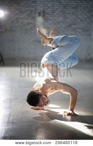 An Athletic Man On Capoeira Training. Standing On The Hands