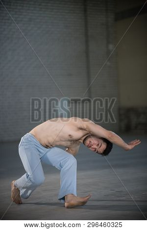 An Athletic Man On Capoeira Training. Standing In The Pose