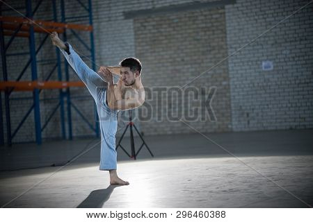 An Athletic Man On Capoeira Training. Performs The Kick In The Air