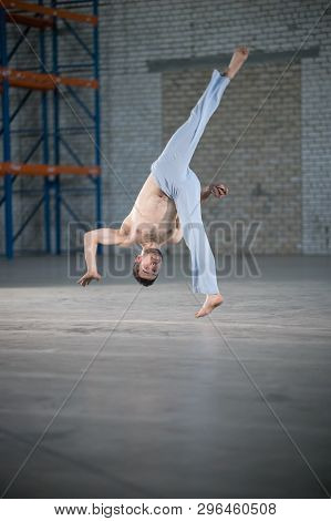 An Athletic Man On Capoeira Training. Flip In Motion