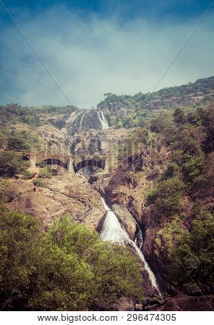 Railway Bridge Over The River Mandovi On The Background Of The Dudhsagar Waterfall
